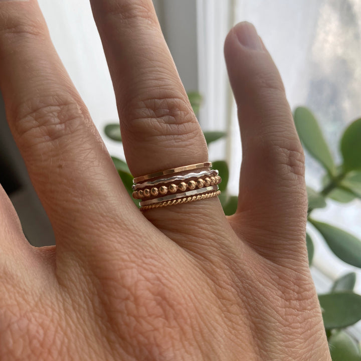 Mixed metal stacking ring set with hammered, beaded, twisted and squiggle rings in sterling silver and 14k gold filled